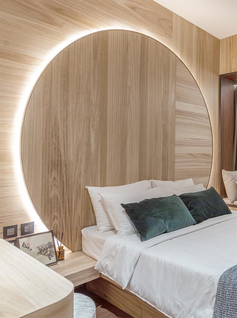 Bedroom Idea - Using natural materials to create a sense of warmth and calm, the design of this circular headboard observes the Chinese concept of “Earth’s a square; heaven a circle”. It also has hidden lighting that creates a soft glow and outlines the design element. #BedroomIdeas #HeadboardIdeas #CircleHeadboard #CircularHeadboard #Lighting