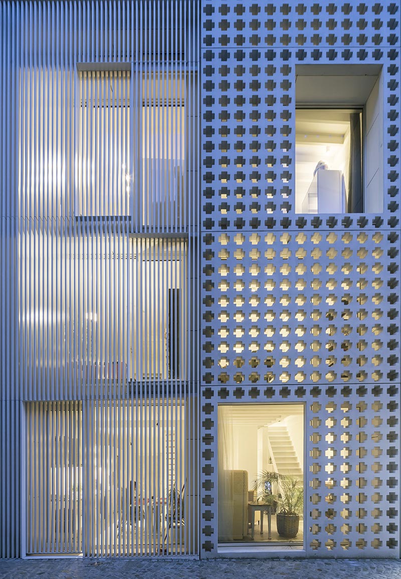 At night, the light from within the apartments highlights the cross-pattern facade and helps to create a shadow effect. #Architecture #PatternedFacade #ModernBuilding