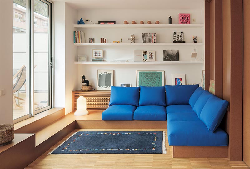 A custom designed shelving unit with a wood slat front is used to hide the radiator in plain sight in this modern apartment. #HideRadiator #Radiator #LivingRoom