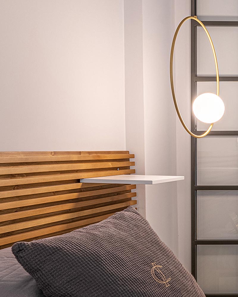 This modern bedroom features a wood slat headboard with shelves that act as bedside tables. #ModernBedroom #HeadboardDesign #WoodSlatHeadboard #BedsideTable #BedroomDesign