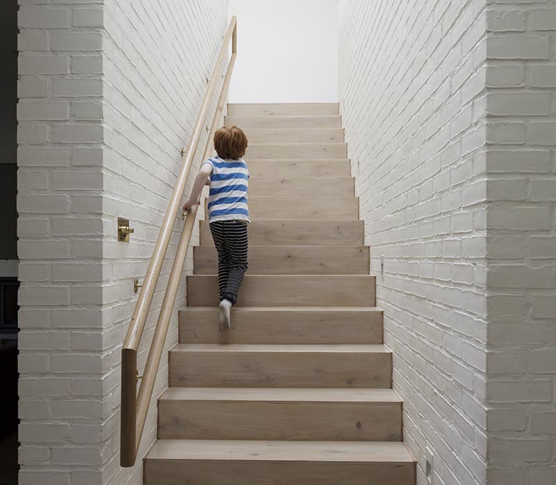 Architecture firm Peter Legge Associates completed a house in Dublin, Ireland, and as part of the design of the stairs, they included a wood handrail that can be used by both adults and children. #StairDesign #HandrailDesign #MultiHeightHandrail