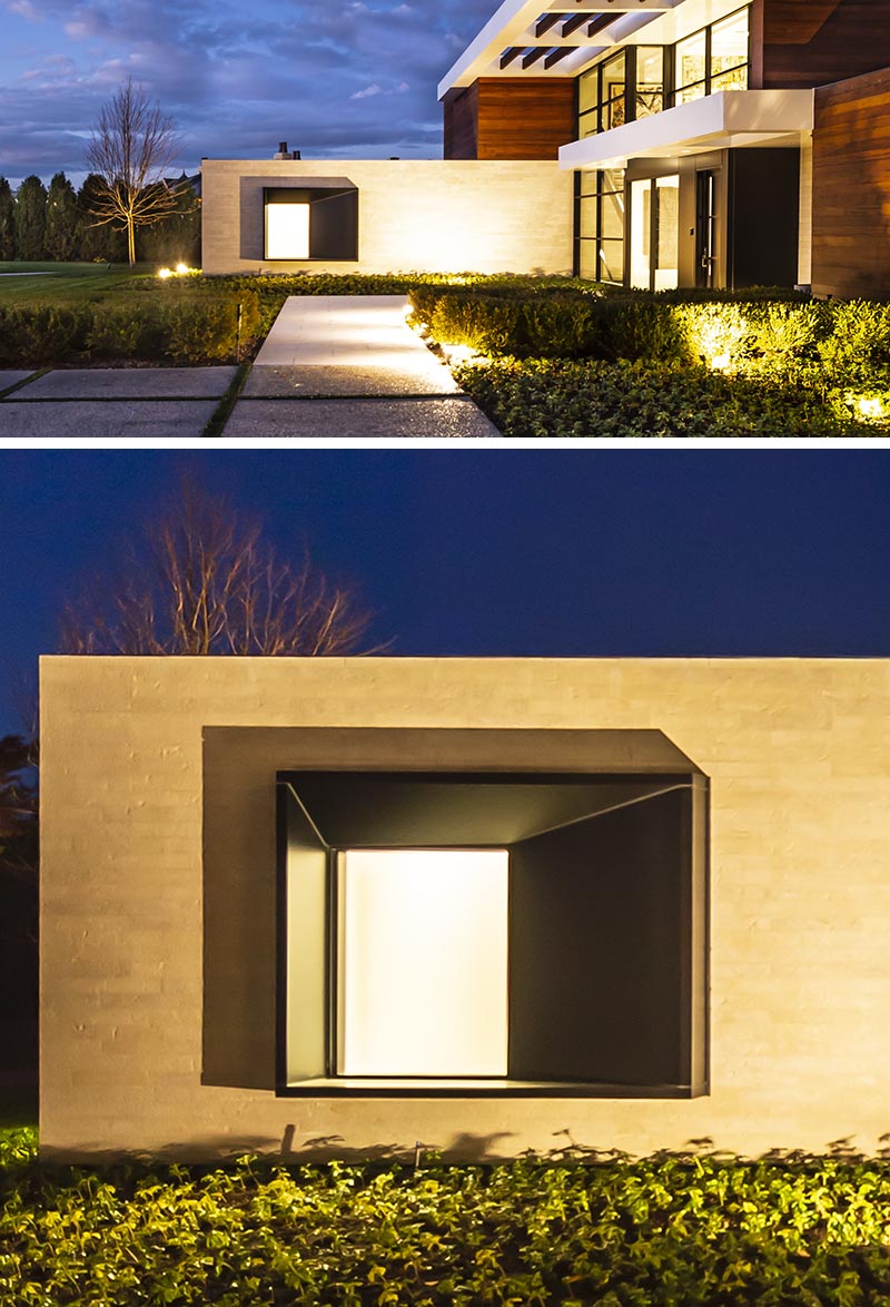 The oversized black steel-clad window frame intentionally juts from the stone entry wall of this modern house, and with its design, it casts a variety of shadows throughout the day, depending on the sunlight or the light coming from within the house. #ProtrudingWindow #WindowDesign #ModernArchitecture #ModernHouse