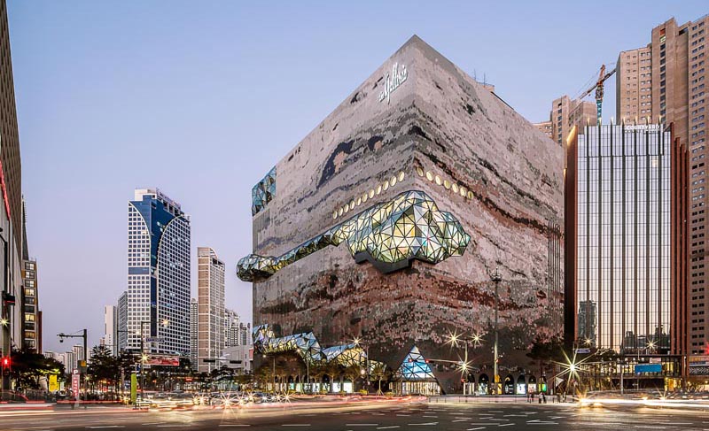 The Galleria department store has a textured mosaic stone facade with multifaceted glass accents that were inspired by the nature of the neighboring park. #DepartmentStore #Architecture #Windows #Facade #BuildingFacade