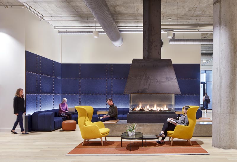 Studio BV has recently completed a lobby fireplace lounge that features rich blue felt wall panels that are stitched together with leather strips, complementing the custom-designed blue sofa and leather accents. #FeltWallPanels #FeltWallCovering #OfficeDesign #LobbyDesign #WorkplaceDesign #FeltPanels