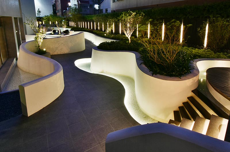 The flowing river of light outdoor space was created using custom curved concrete forms that create space for lighting and plants. #OutdoorSpace #Landscaping