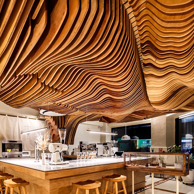 The attractive ceiling sculpture in this cafe is called "Shading tree", and it starts from the preparation zone, and covers the customer area to create a unique atmosphere. #CafeDesign #SculpturalCeiling #CoffeeShop #InteriorDesign