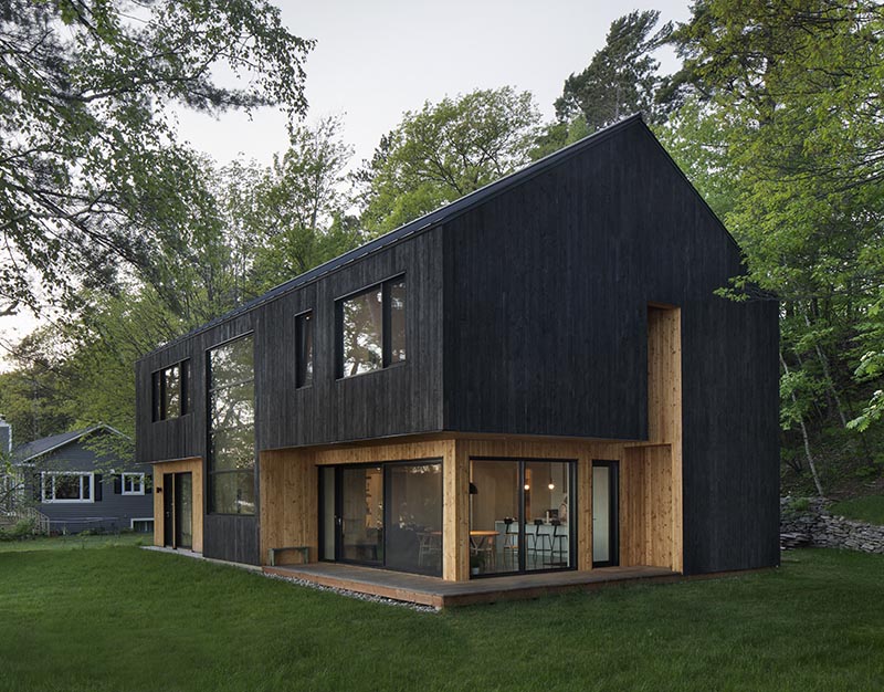 The exterior of this modern house is clad in larch, which is a type of pine tree, and has been charred to give it that burnt look. It also contrasts the recessed wood that's been finished with a natural oil. #BlackHouseSiding #BlackHouse #CharredWoodSiding #ShouSugiBan #BurntWoodSiding
