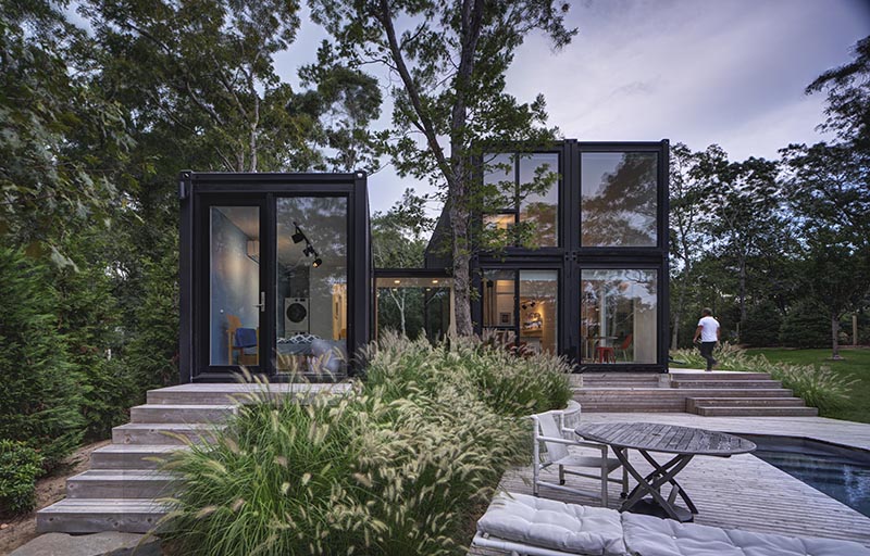MB Architecture has designed a modern shipping container house for a family of five, that's located on a wooded site in Amagansett, New York. #ShippingContainerHouse #BlackHouse #ModernHouse #ModernArchitecture #ShippingContainer #Landscaping