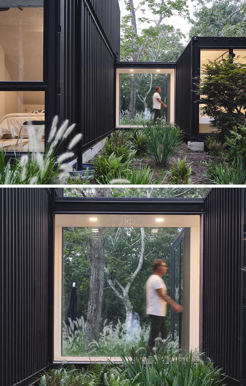 A window-lined bridge connects the main living spaces of this modern shipping container house to a single container that houses two bedrooms, and is placed slightly away from the main building to create courtyard-like outdoor spaces. #ShippingContainerHouse #Bridge #Windows #ModernArchitecture #BlackHouse