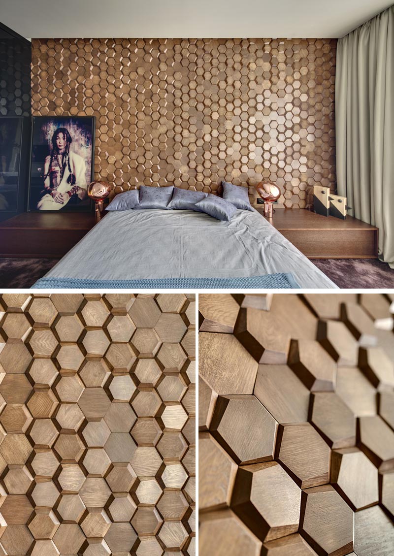 This modern bedroom has an eye-catching accent wall made from 3-dimensional hexagonal wood tiles in a honeycomb pattern. #WoodTiles #WoodAccentWall #3DAccentWall #BedroomDesign #InteriorDesign