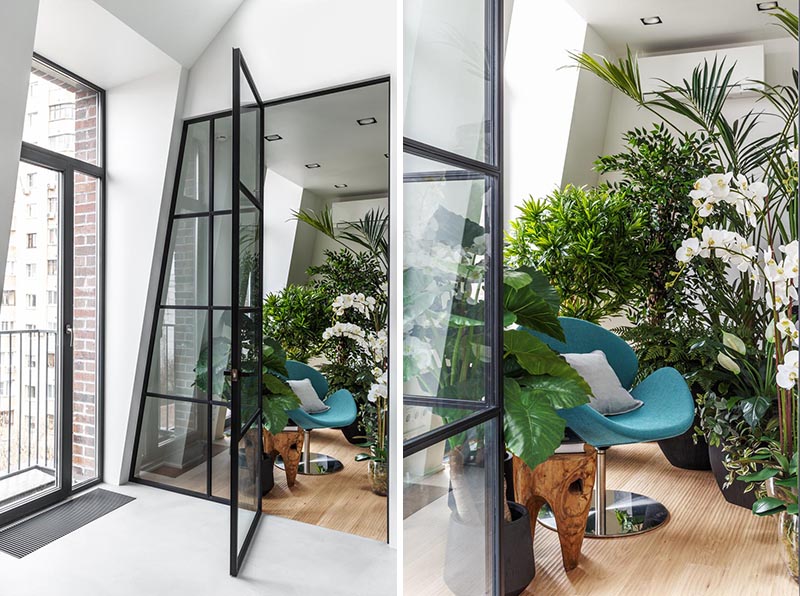 This modern apartment features an indoor plant room that can be seen through a black-framed glass wall, with a door that opens to reveal a quiet and peaceful sitting area. #IndoorGarden #IndoorPlantRoom #IndoorGardenRoom #ReadingNook #InteriorDesign