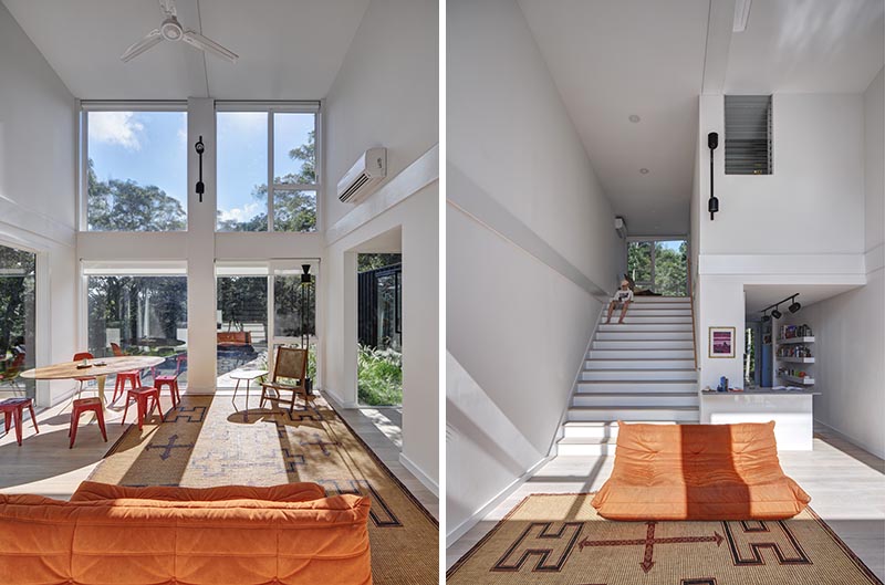 As shipping containers are quite narrow, the architects of this modern house opted to stack the containers, carving out the interior floor/wall/ceiling to create a large open living space and kitchen with stairs that lead up to a lofted bedroom. By finishing the interior white, it makes the all of the interiors feel brighter and larger. #ShippingContainerHouse #DoubleHeightLivingRoom #Stairs #LivingRoom #ShippingContainer