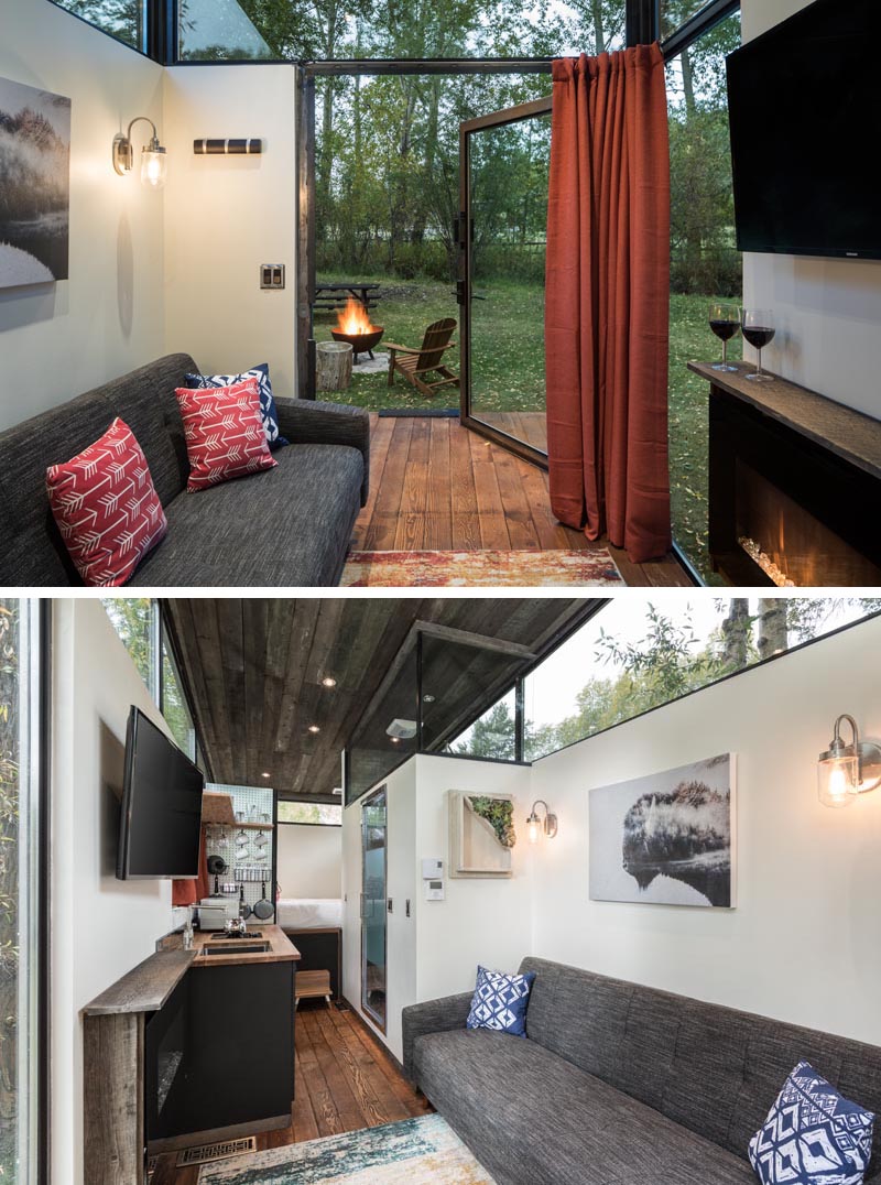 This modern tiny house is built on a steel frame with wheels so it can be easily transported to any site, and an oversized doors connects the deck to the living room, that features a 10 foot ceiling. #TinyHouse #TinyHome #LivingRoom