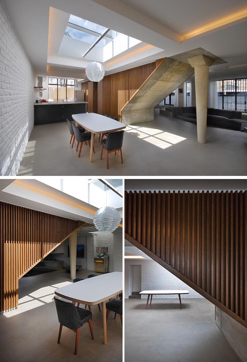 This centrally located staircase with a wood slat exterior adds a sense of warmth to the open interior, but also contrasts the white washed brick walls. #WoodStairs #StairDesign #WoodSlats #ModernInterior