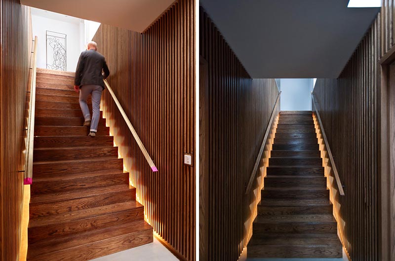 This modern house has a staircase with wood slat walls, handrails on both sides, and hidden lighting. #StairDesign #WoodStairs #StairLighting #HiddenStairLighting #StairHandrails