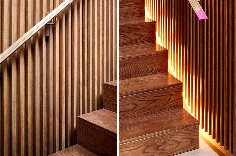 This modern house has a staircase with wood slat walls, handrails on both sides, and hidden lighting. #StairDesign #WoodStairs #StairLighting #HiddenStairLighting #StairHandrails