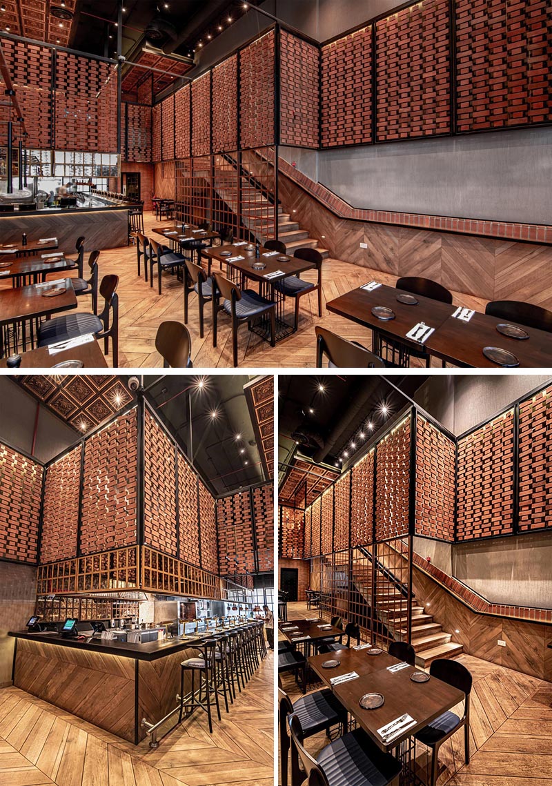 Open brick walls wrap around the different areas of this restaurant, like above the kitchen and along the stairs. They provide visiual interest and a sense of privacy on the upper level of the interior, without blocking the light. #RestaurantDesign #BrickWalls #ScreenIdea #BrickScreen