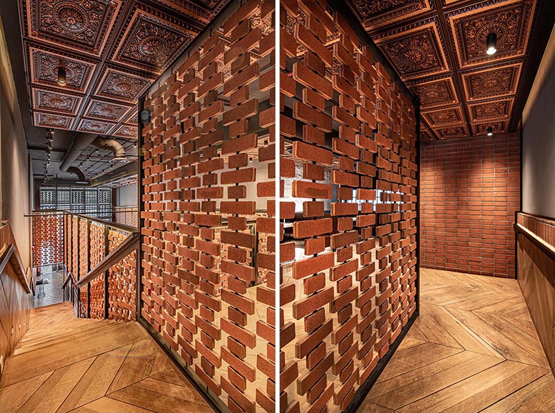 Open brick walls wrap around the different areas of this restaurant, like above the kitchen and along the stairs. They provide visiual interest and a sense of privacy on the upper level of the interior, without blocking the light. #RestaurantDesign #BrickWalls #ScreenIdea #BrickScreen