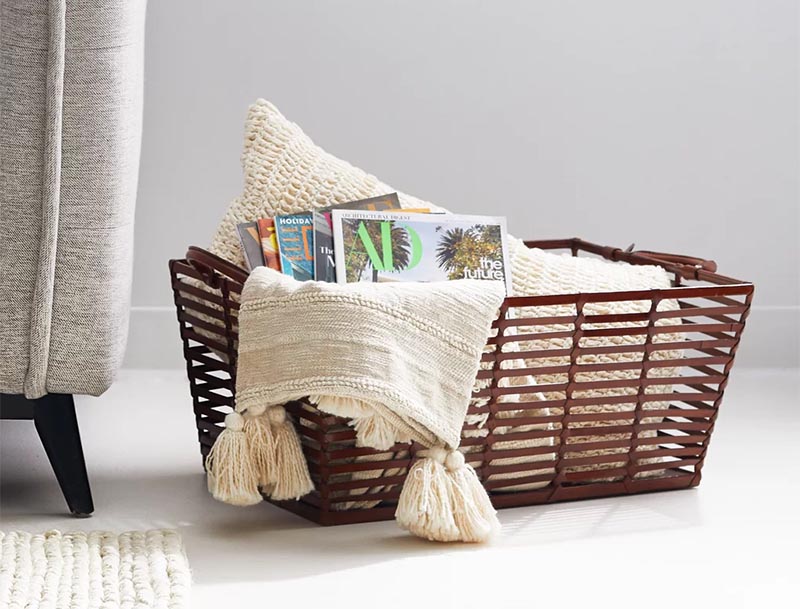 For a casual storage idea, a simple but effective solution is a basket. You can keep it in the corner of the room, and when needed, a blanket can be thrown into it, without the need of keeping it folded. #StorageBasket #HomeDecor #BlanketStorage
