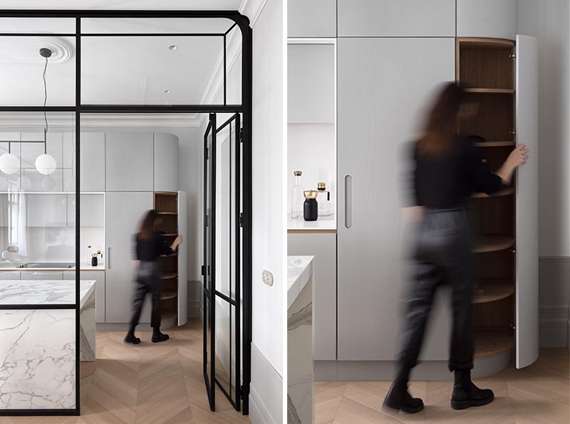 Curved cabinets on either end of the kitchen soften its appearance, and when opened, reveal custom shelving that matches the shape of the cabinet. #KitchenDesign #CornerCabinets #KitchenCabinets #Interiors #InteriorDesign