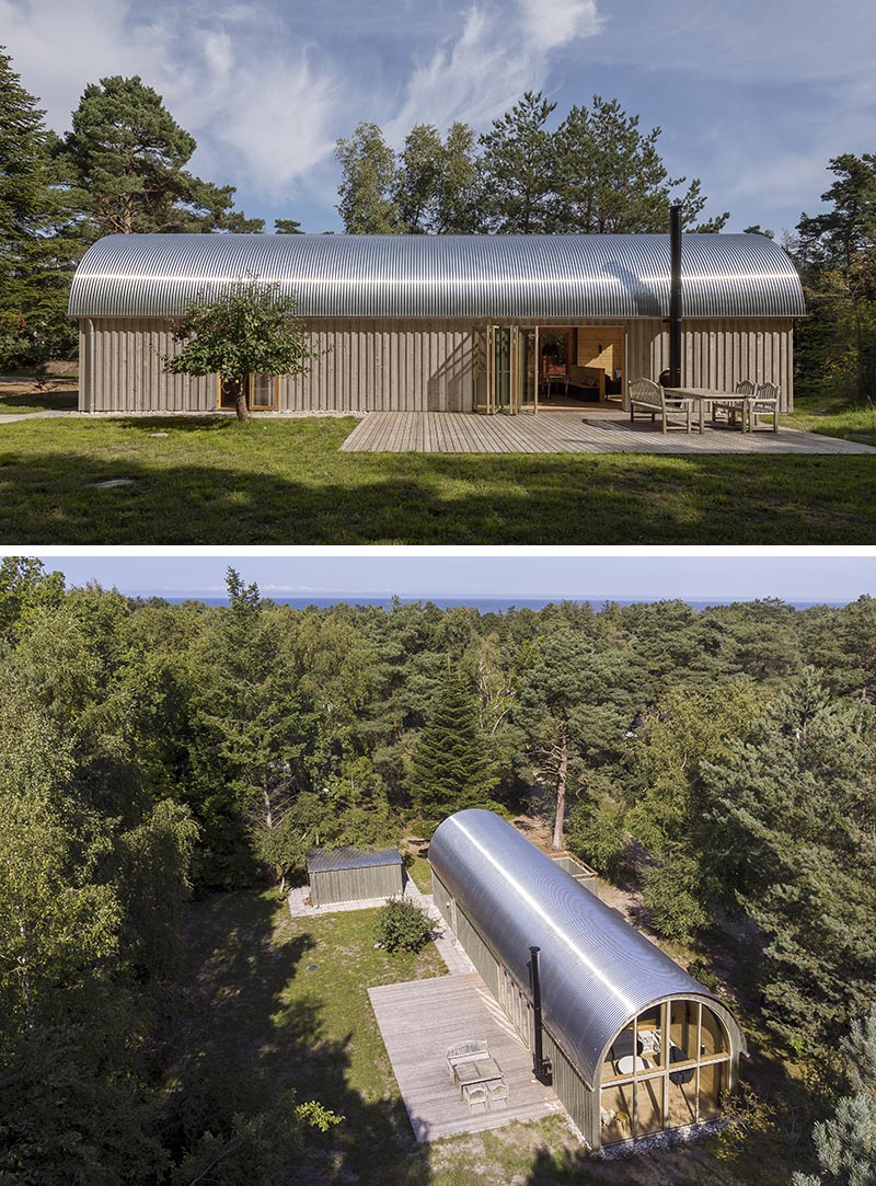 Valbæk Brørup Architects has designed a modern summer house that features a corrugated metal roof and a warm wood interior with a vaulted ceiling. #CorrugatedMetalRoof #MetalRoof #CurvedRoof #ModernArchitecture #ModernHouse