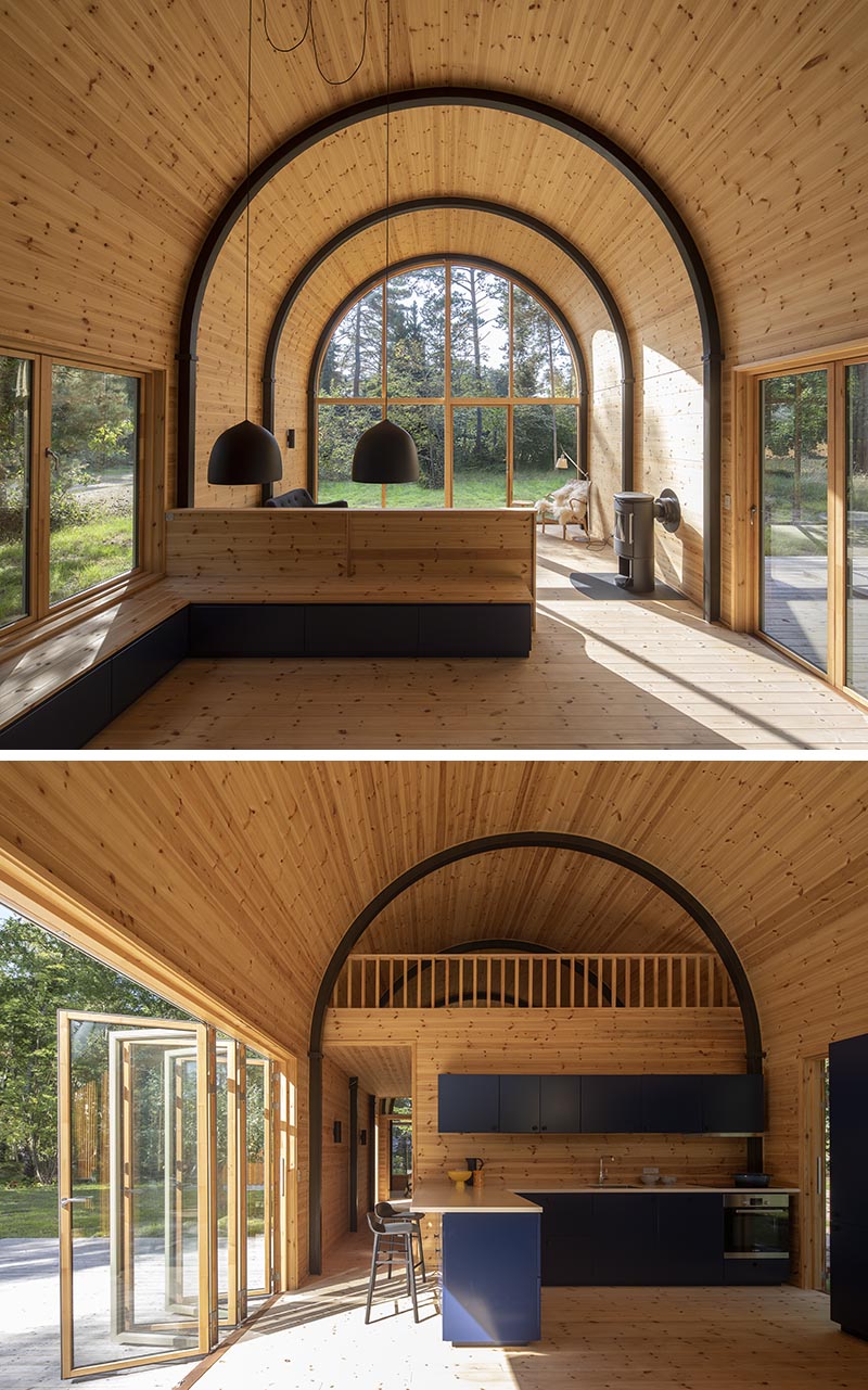 Inside this modern house with a curved vaulted ceiling, there's 8 eye-catching arched steel beams that provide the support for the structure, and at the same time, they create a strong contrast to the minimalist pine wood interior. #CurvedCeiling #VaultedCeiling #PineInterior #WoodInterior #ArchedBeams #SteelBeams #ModernHouse