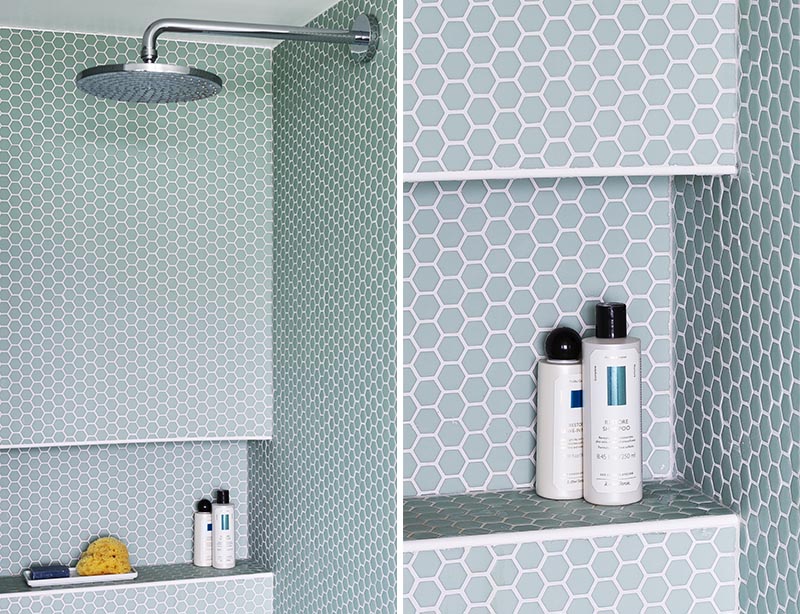 This modern bathroom features a shower lined with light blue hexagon penny tile, and also has a built-in shower niche. #ShowerNiche #PennyTile #ShowerIdeas #BathroomIdeas