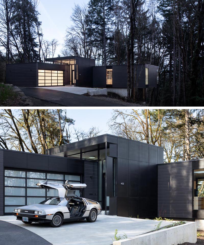 A garage with an opaque door sits beside the front door that welcomes visitors to the home. #ModernGarage #ModernHouse #BlackHouse