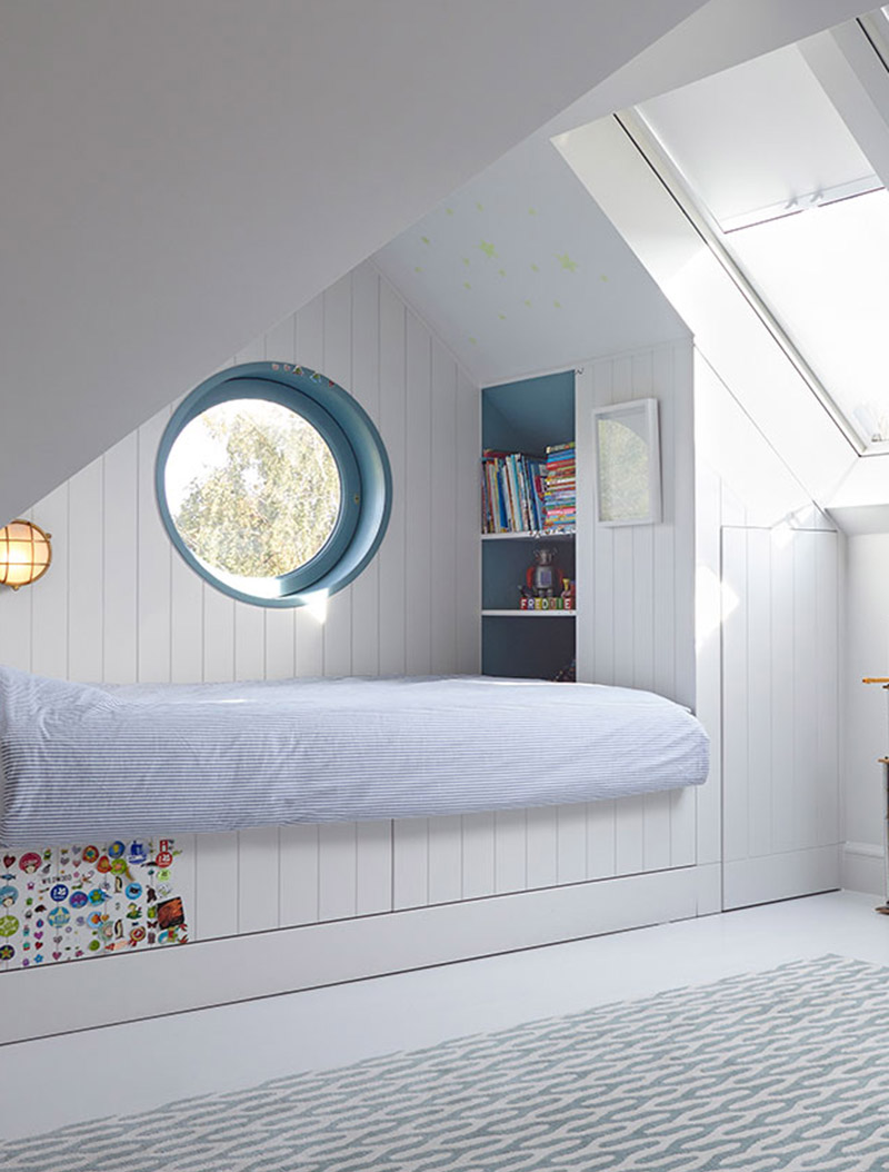 This modern kids bedroom has a built-it bed that's been tucked into one end of the room, creating an open play area that's softened by the use of a modern rug, and includes storage in the form of a closet and bookshelf. #KidsBedroom #ModernKidsBed #BuiltInBed #Interiors #BedroomDesign