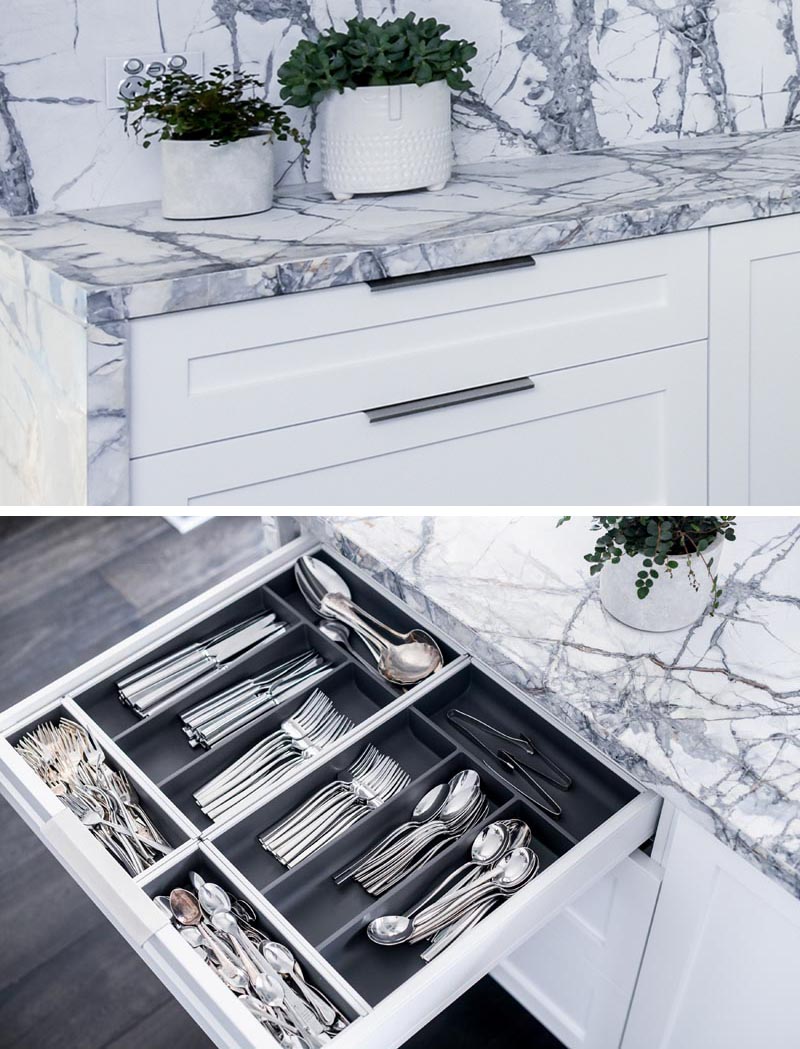 This modern grey and white kitchen has a dedicated drawer just for formal cutlery, with designated sections for the different types. #KitchenDesign #KitchenIdeas #KitchenStorage #KitchenOrganization #KitchenDrawers #CutleryStorage