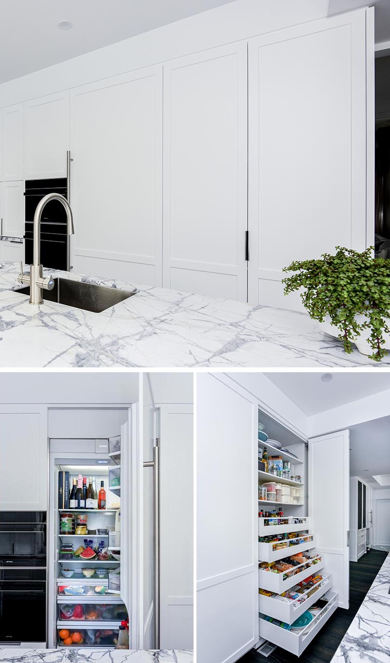 This modern grey and white kitchen as an integrated fridge and a pantry cupboard. To make the most of the available space, the pantry has wide but shallow pull-out drawers that allow for the easy storage of a variety of items. #PantryIdeas #IntegratedFridge #ModernKitchen #KitchenIdeas #KitchenStorage #KitchenOrganization