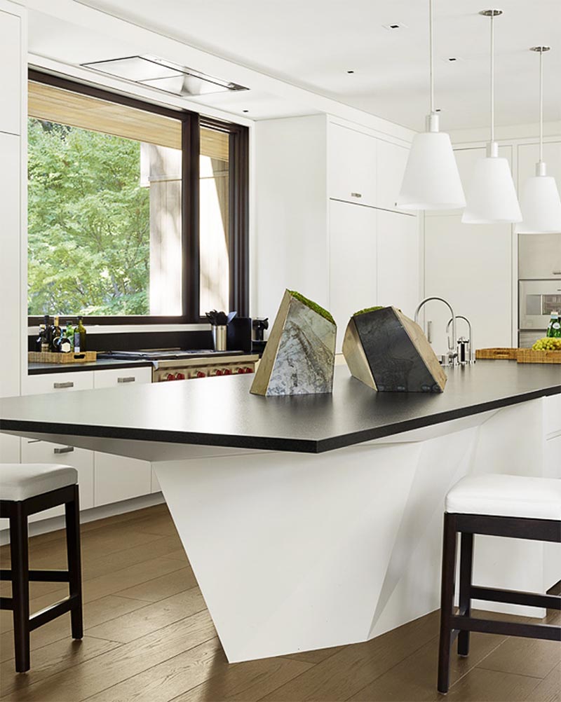 A geometric kitchen island that features a black countertop.