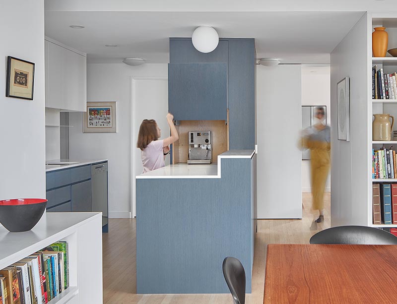 Aiming to keep the countertops clutter free, this appliance garage blends into the surrounding matte blue cabinets of this modern kitchen. #ApplianceGarage #CoffeeStation #KitchenDesign #MatteBlueKitchen #WhiteCountertops
