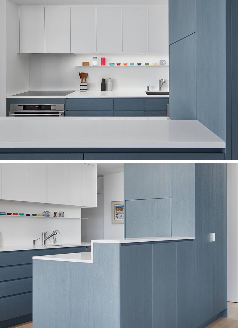 Aiming to keep the countertops clutter free, this appliance garage blends into the surrounding matte blue cabinets of this modern kitchen. #ApplianceGarage #CoffeeStation #KitchenDesign #MatteBlueKitchen #WhiteCountertops