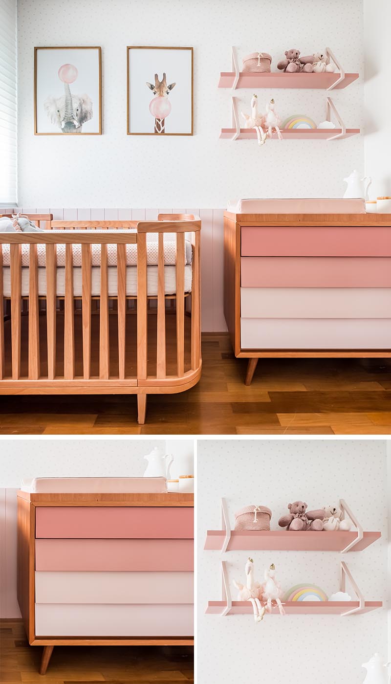 This modern pink nursery has a wall that's home to the crib, a dresser and change station, and custom-designed shelving by Rua 141. The drawers of the dresser were painted in a pink gradient to soften the furniture piece. #ModernNursery #PinkNursery #GirlsBedroom #InteriorDesign #Interiors #NurseryRoom #BabyRoom