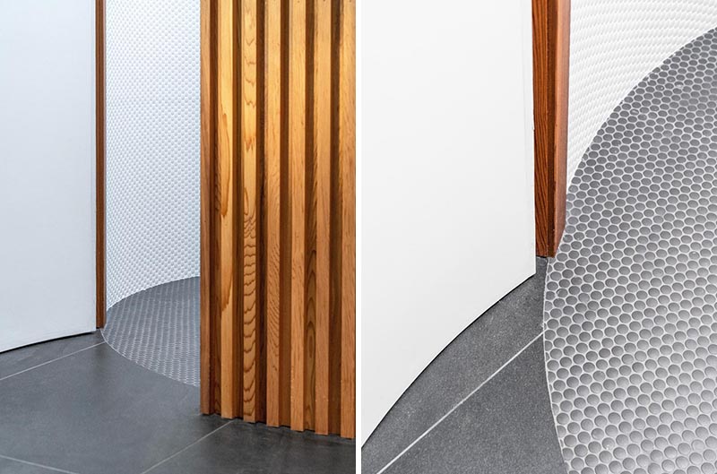 Grey penny tiles with white grout color match the grey large format tiles found throughout this modern pool house. #PennyTiles #GreyTiles #TileFlooring #BathroomFlooring