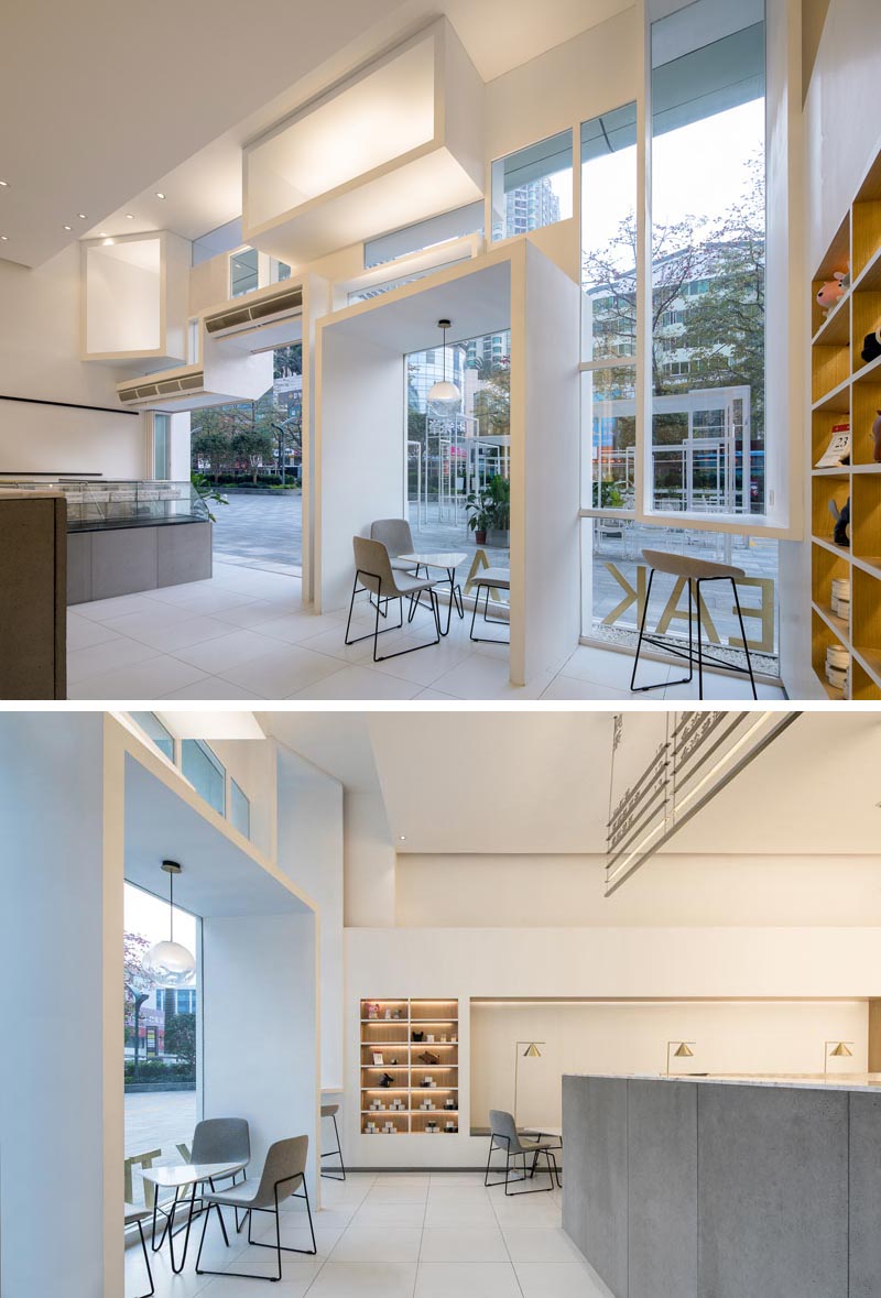 Inside this modern tea store, the high ceilings create a bright and open space, while the boxes shown on the facade of the store, penetrate through to the interior, creating a seating nook and a bar area. #TeaStore #TeaShop #CafeDesign #RetailDesign