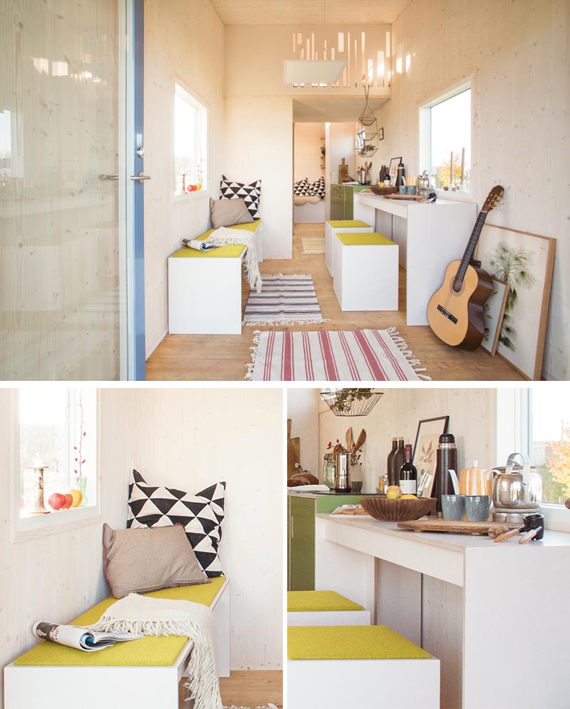 Inside this modern tiny house, there's a small open space before moving into a dining area with a bench, as well as a couple of stools and a table underneath the window. #TinyHouse #TinyHome #SmallLiving #TinyHouseDesign #TinyHouseLayout