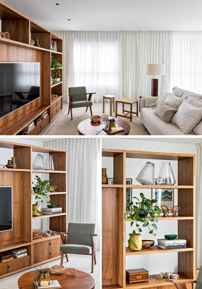This modern room divider, made from Freijó wood, creates a space to welcome residents and visitors before reaching the open floor plan of the living room, kitchen, and dining area. From the living room side, the shelving unit provides a designated area for the TV in the living room, as well as storage in the form of bookshelves and drawers. #RoomDivider #WoodRoomDivider #WoodPartition #WoodShelving #LivingRoom #InteriorDesign #Interiors