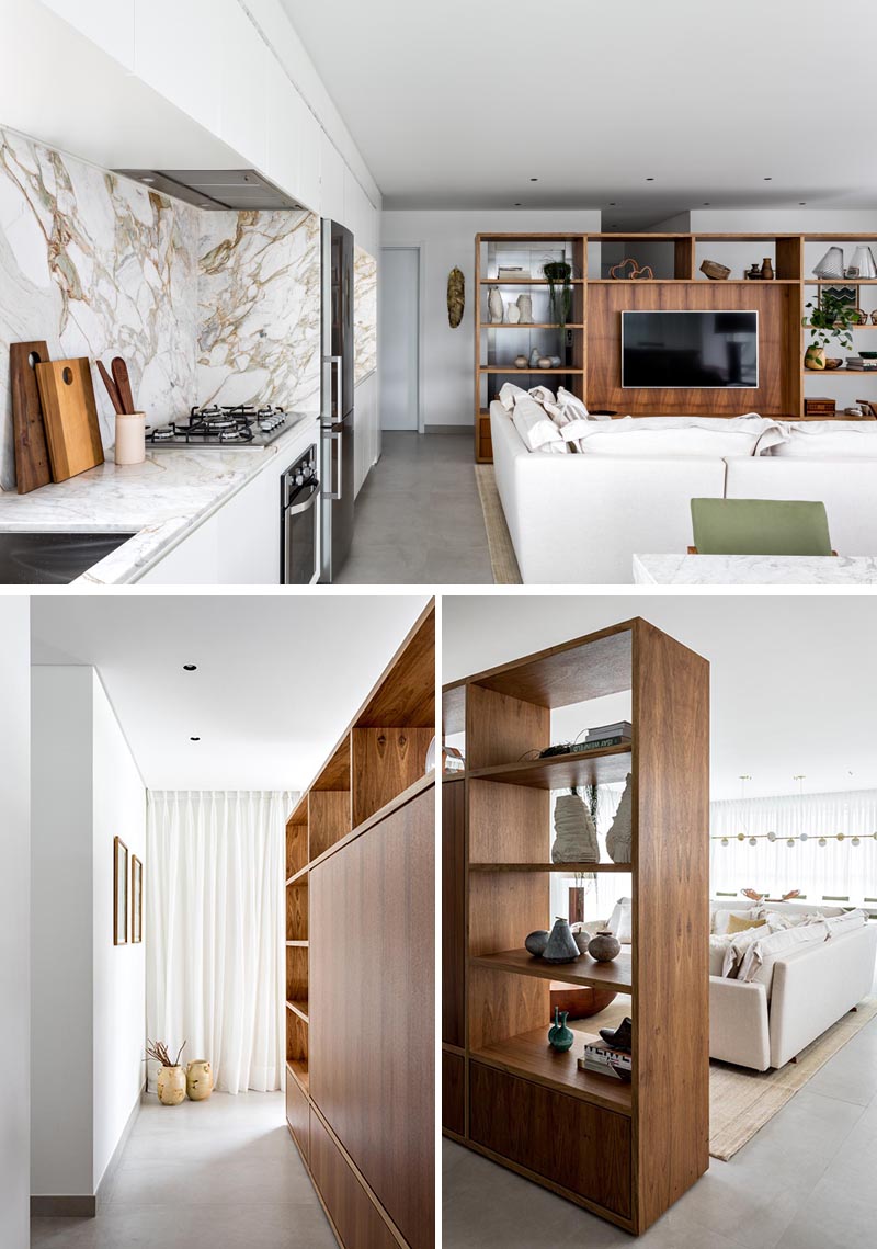 This modern room divider, made from Freijó wood, creates a space to welcome residents and visitors before reaching the open floor plan of the living room, kitchen, and dining area. From the living room side, the shelving unit provides a designated area for the TV in the living room, as well as storage in the form of bookshelves and drawers. #RoomDivider #WoodRoomDivider #WoodPartition #WoodShelving #LivingRoom #InteriorDesign #Interiors
