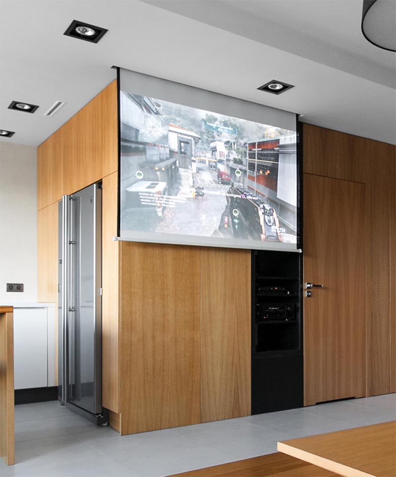 Architecture and interior design firm mode:lina has completed an apartment in Poznan, Poland, and instead of mounting a television in the living room, they included a drop-down projector screen. #DropDownProjectorScreen #ProjectorScreen #InteriorDesign #LivingRoom