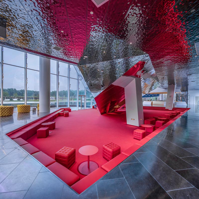 A sunken built-in red seating area in an office building.