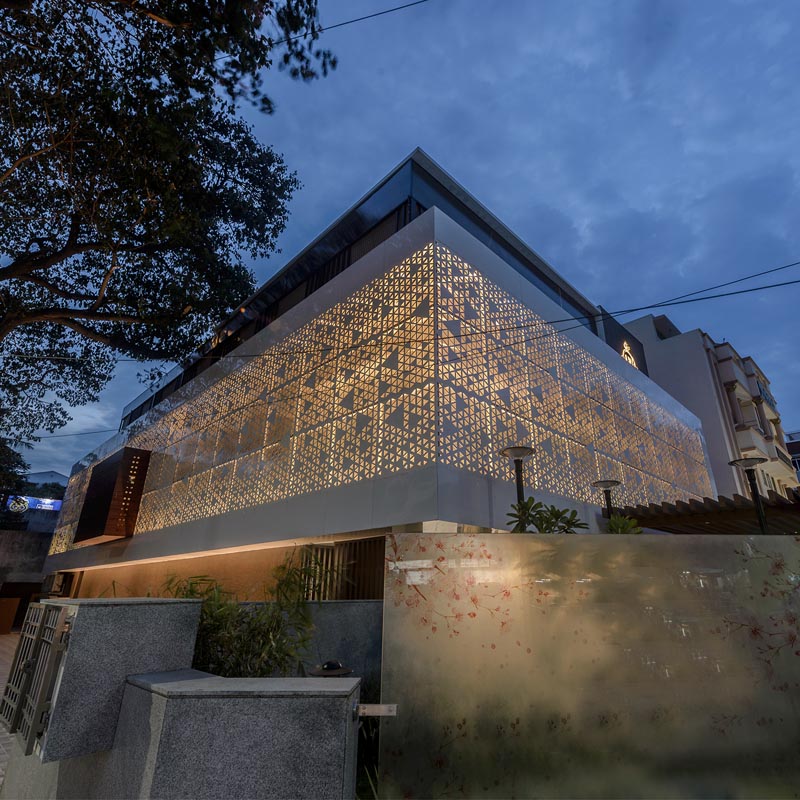 A perforated screen wraps around a modern house.
