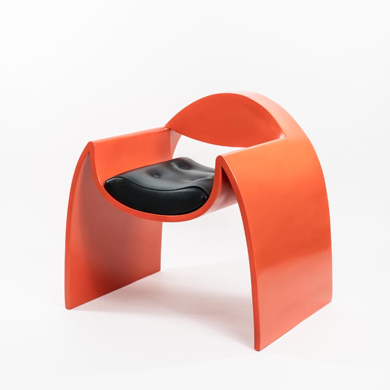 A curved armchair with a bright orange finish.