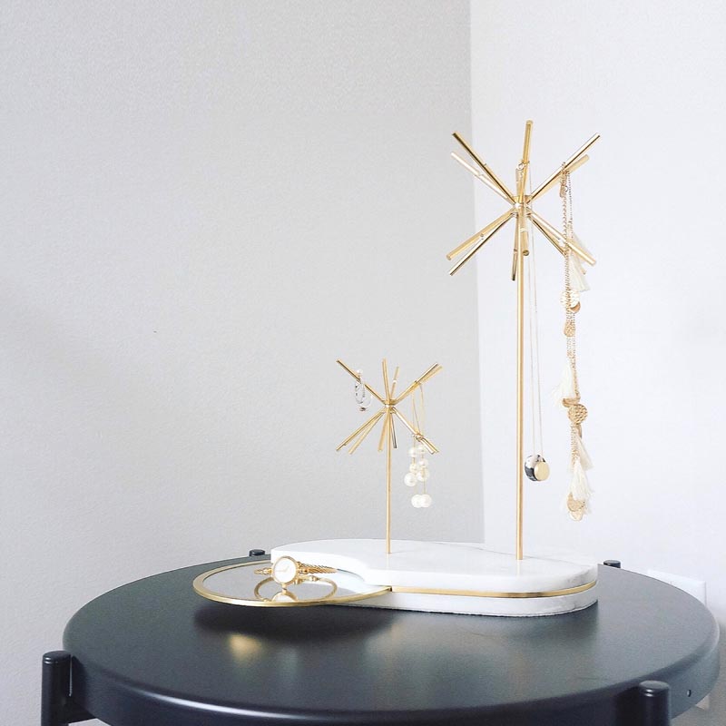 A modern white and gold jewelry stand.