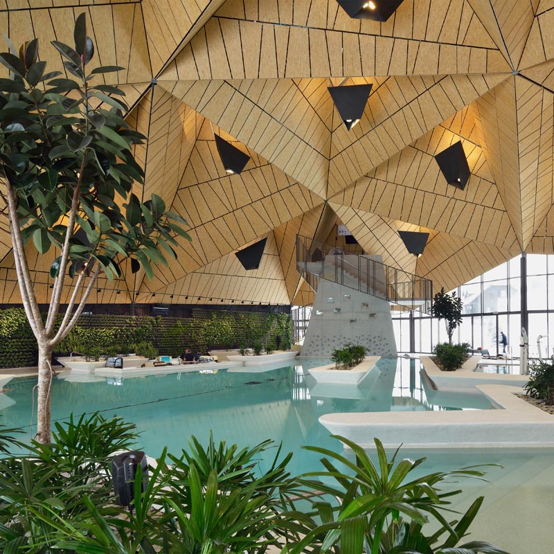 A public swimming pool with an angular wood ceiling.