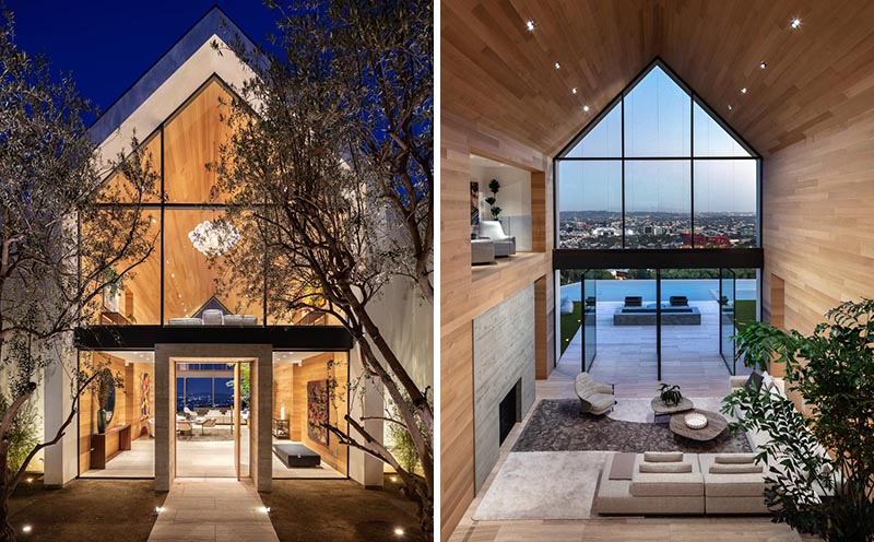 The eye-catching gabled design of this modern barn-inspired house, is easily seen upon approach to the house, and once inside, the wall of windows and doors at the other end of the wood-lined great room showcase the swimming pool and view. #ModernHouse #ModernArchitecture #HouseDesign #GabledRoof #GreatRoom