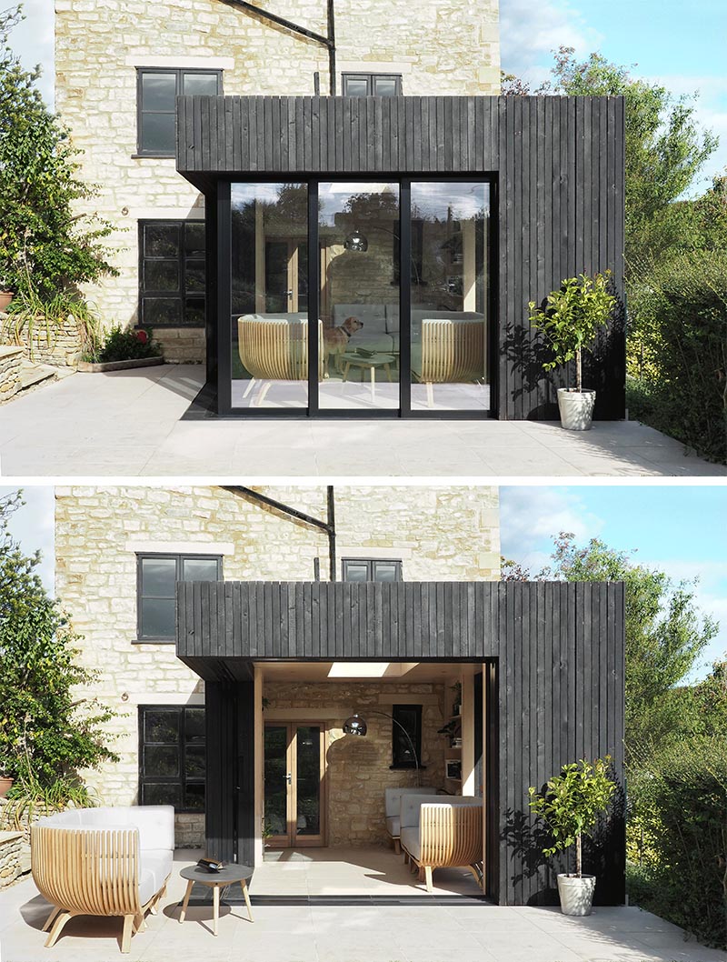 With its charred wood siding and black door frames, this modern reading room is a contrast to the original stonework of the cottage, however it also complements the black window frames and iron work. #ModernArchitecture #BlackWoodSiding #ReadingRoom #HomeOffice