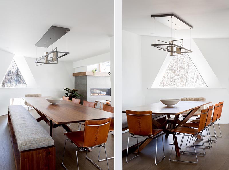 This modern dining room in a geodesic dome house features a custom built table and bench, which are surrounded by vintage leather chairs, and above, a sculptural lighting element by Hubbardton Forge. #DiningRoom #GeodesicDome #InteriorDesign #ModernDiningRoom