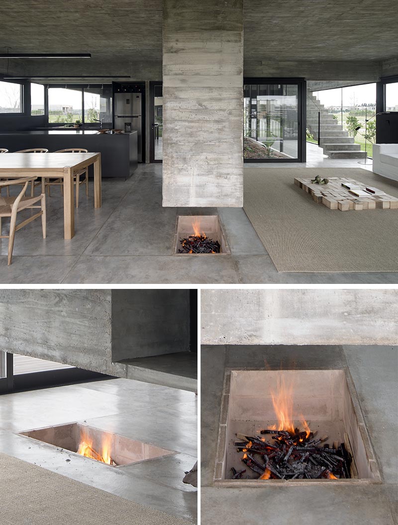 Designed as a sculptural element that separates the dining room and the living room, this modern hanging concrete divider has a chimney built into it on one end, and the other is a platform for holding the television. Underneath, the fireplace has been built into the ground. #Fireplace #RoomDivider #ConcreteDivider #HangingConcreteChimney #Concrete